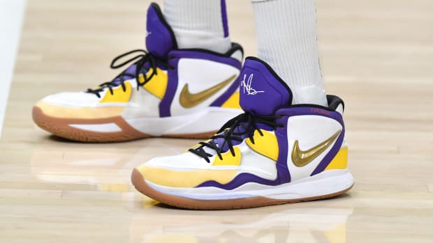 View of white, purple, and gold Nike Kyrie shoes.